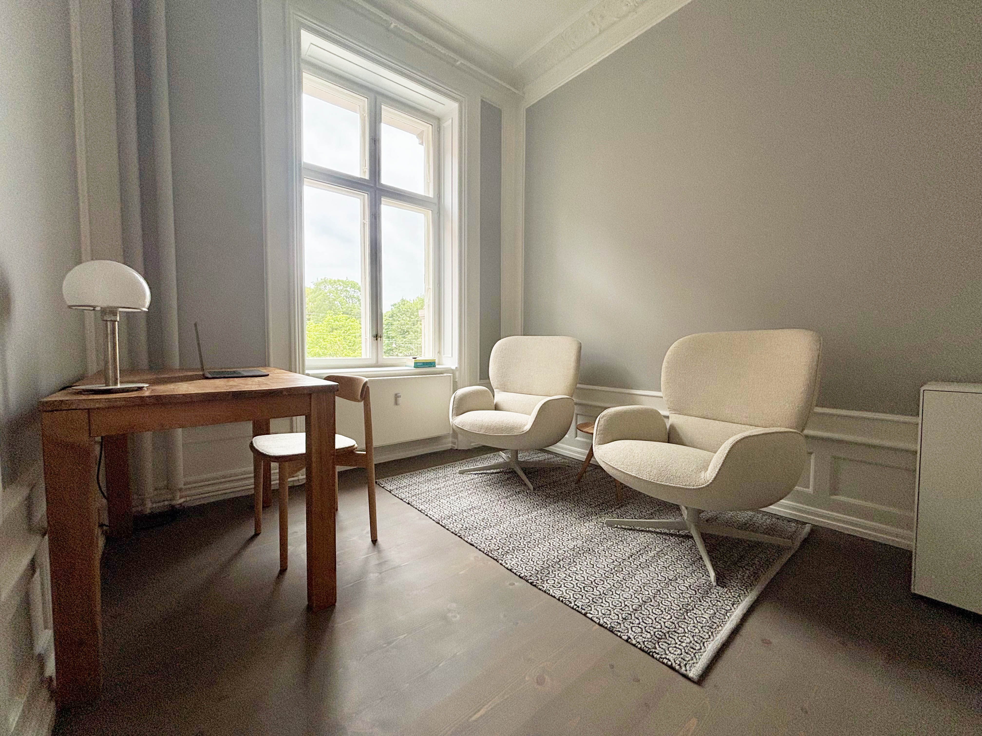 Coachingraum von Glow Coaching in Copenhagen mit zwei gemütlichen Sesseln und Blick in Natur